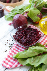 Grated beetroots in bowl on table close-up