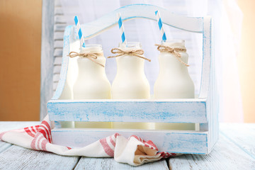 Milk in bottles with paper straws on table