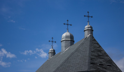 Three spires and rosses on top of old country church.