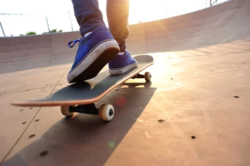 Afwasbaar fotobehang  skateboarding woman legs at sunrise skatepark  © lzf