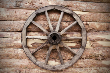 Fototapeta na wymiar rustic wagon wheel hanging on a wall