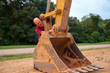 Man working on backhoe bucket