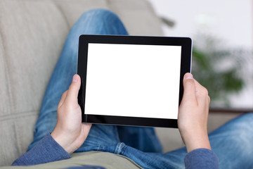 man lying on a sofa and holding a tablet with isolated screen