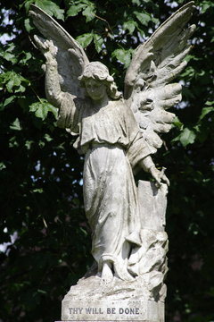 	 stone statue of woman angel with wings in cemetery	