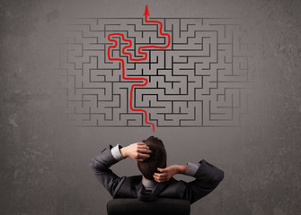Business man looking at a maze and the way out