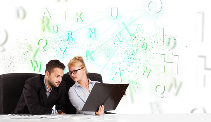 Business people at desk with green word cloud