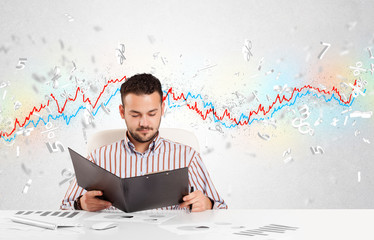 Business man sitting at table with stock market graph