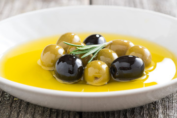 fresh olive oil and olives in a plate, close-up
