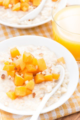 oatmeal with fresh apricots and nuts, orange juice, top view