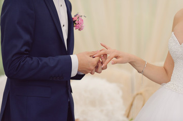 Obraz na płótnie Canvas Groom Putting on Ring on Bride's Finger