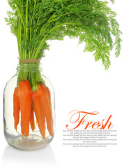 Fresh carrots with leaves in glass jar isolated