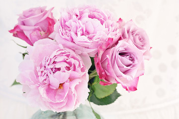 Close-up floral composition with a pink peony and roses