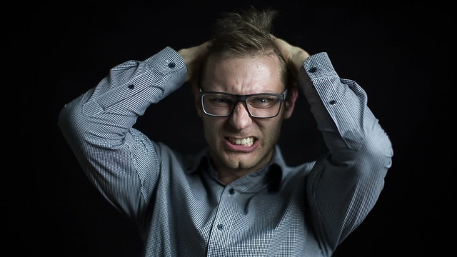 Angry man with glasses shouting on a black background