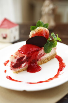 close up strawberry cheese cake in white dish