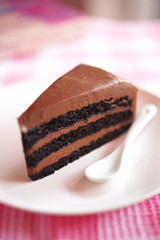close up brownie and chocolate cream cake in white dish