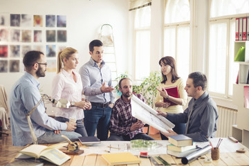 Group of Architects Sitting Around Table Having Meeting