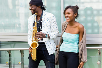 Afrikanisches Paar spielt Saxophon auf Straße