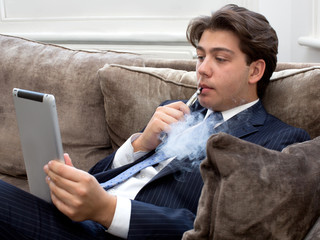 Young man relaxing with an e-cigarette