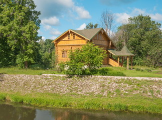 Landscape with a wooden small house in forest by the river