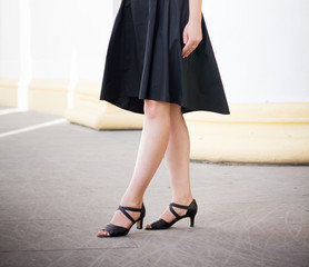 Legs of girl staying near old columns