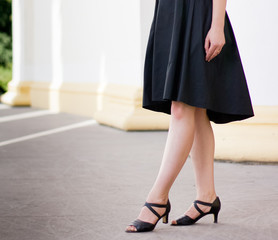 Legs of girl staying near old columns