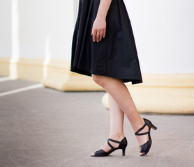 Legs of girl staying near old columns