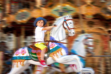 Fototapeta na wymiar Cute kid, riding on a carousel