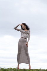 Fototapeta na wymiar Young woman in sexy long gray dress