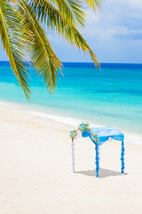 wedding arch decorated with flowers on tropical sand beach, outd