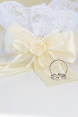 wedding rings and decoration over white