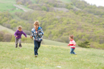 three young happy children having fun on natural background