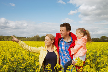 happy family outdoor in rape field