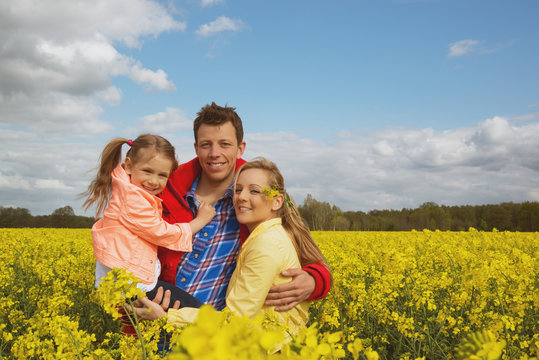 Happy Family Outdoor In Rape Field