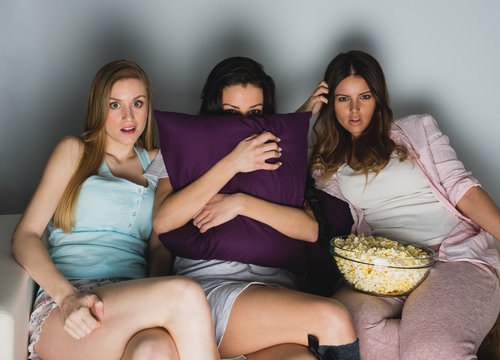 three friedns watching a scary movie