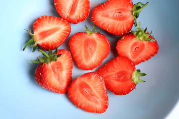 Fresh strawberries in a blue bowl, close up