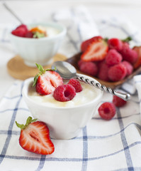 Yogurt with berries and honey  in small bowl