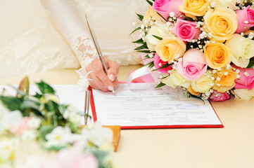 Bride signing marriage license or wedding contract