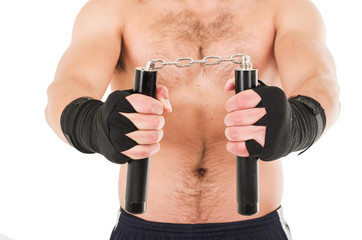 Fototapeta na wymiar martial arts fighter holding black nunchucks with his hands