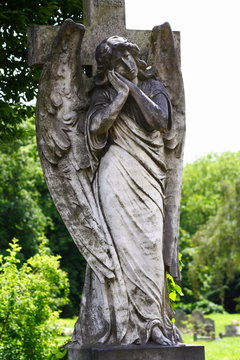 stone statue of woman angel with wings in cemetery
