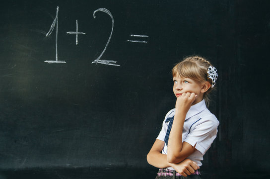 happy school girl on math classes finding solution and solving p