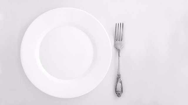 Vintage cutlery set and plate appear on a white background.