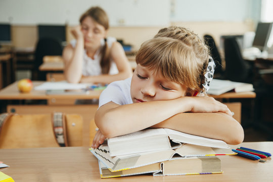 little schoolgirl sleep in classroom near blackboard