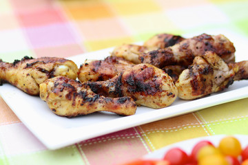Delicious grilled chicken legs on white plate
