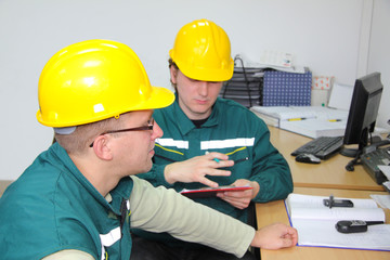 Industrial workers in control room, teamwork