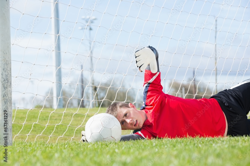 Poster goalkeeper in red making a save