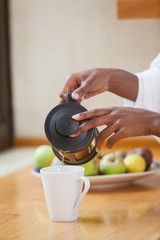 Woman in bathrobe pouring coffee