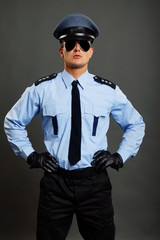 Young policemen in uniform with sunglasses standing