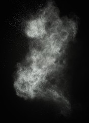 White powder exploding isolated on black
