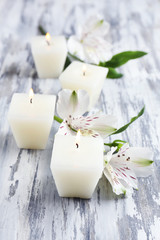 Fototapeta na wymiar Beautiful candles with flowers on wooden background