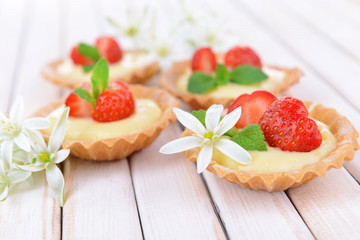 Tasty tartlets with strawberries on table close-up